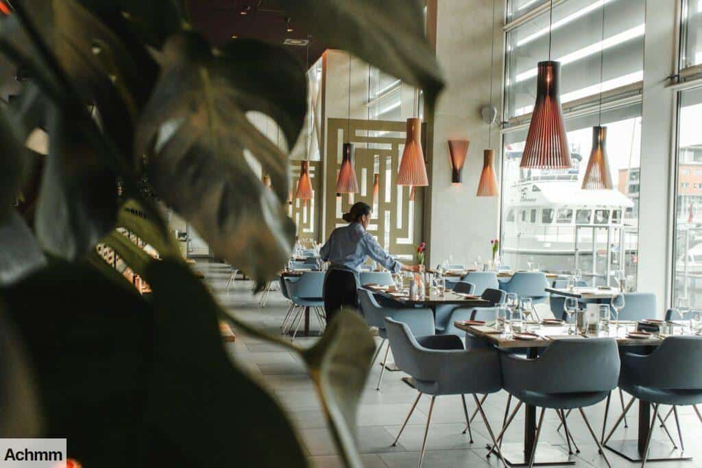 woman in front on brown dining table and chairs inside building