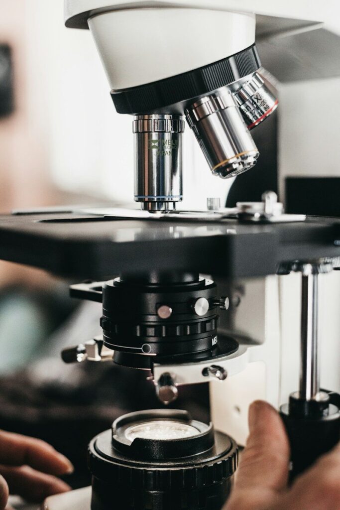 Persona ajustando el enfoque de un microscopio en un laboratorio