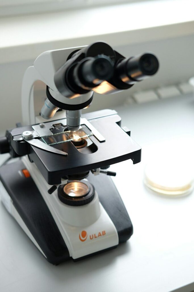 Microscopio sobre una mesa blanca listo para analizar una muestra